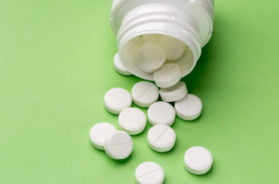 Round white pills and plastic pill bottle