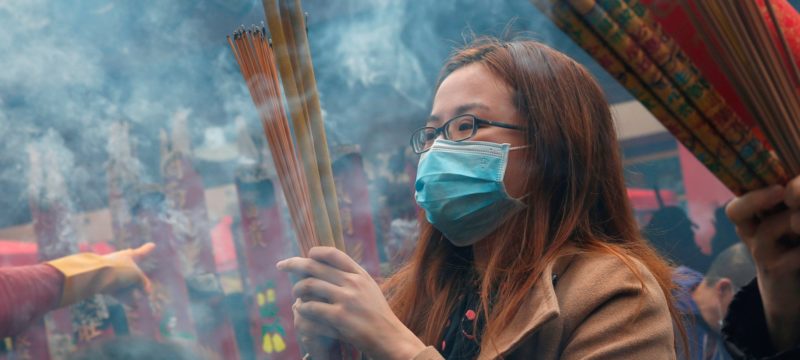 Worshippers wear masks to prevent an outbreak of a new coronavirus as they make offerings of incense sticks during a Lunar New Year celebration at Che Kung Temple, in Hong Kong
