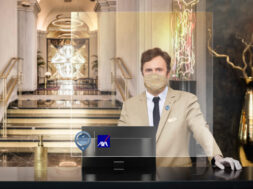 Portrait of confident male receptionist standing at counter in hotel