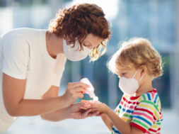 Mother and child with face mask and hand sanitizer