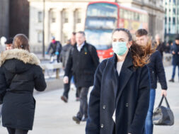 Young woman wearing face mask while walking in the streets of London