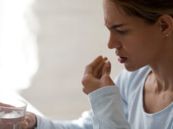 Close up unhealthy woman hold glass still water and pill