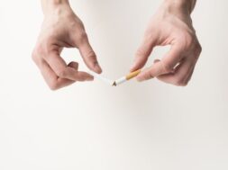person-s-hand-breaking-cigarette-white-background
