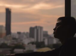 man-looking-out-city-view-from-room_74663-510