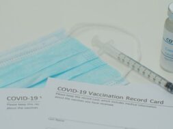 medical-mask-covid-19-vaccine-vaccination-record-card-approved-by-cdc-with-corona-virus-vaccine-vials_299057-47