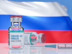 syringe-with-needle-is-inserted-into-vial-labeled-word-covid-19-vaccine-flag-russia-surface_37129-1396