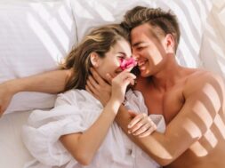 cheerful-young-couple-love-lying-white-bed-enjoying-honeymoon-sunny-morning-smiling-handsome-man-with-bronze-skin-embracing-his-magnificent-girlfriend-vintage-blouse-resting-pillows_197531-3184