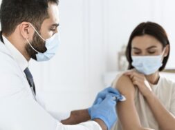 doctor-vaccinating-young-woman_23-2148755633