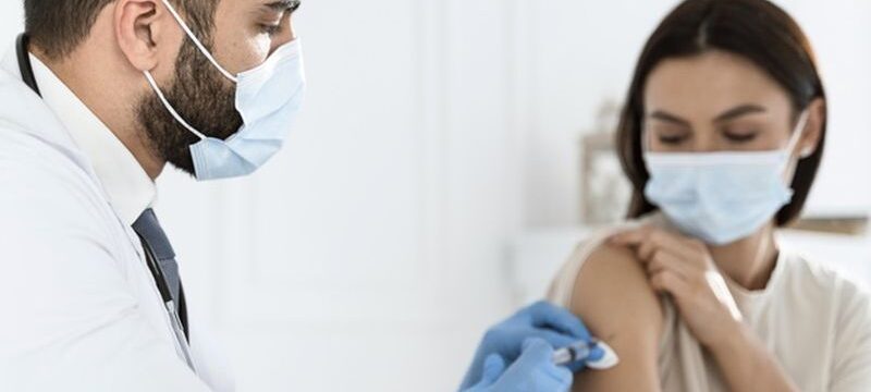 doctor-vaccinating-young-woman_23-2148755633