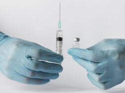 front-view-doctor-putting-vaccine-syringe