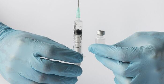 front-view-doctor-putting-vaccine-syringe