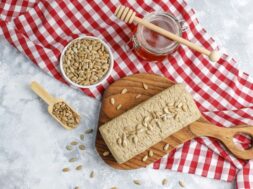 Homemade sunflower halva on cutting board with sunflower seeds