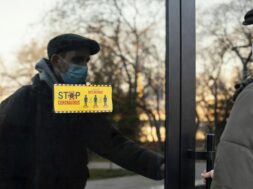 man-with-mask-opening-door_23-2148863843
