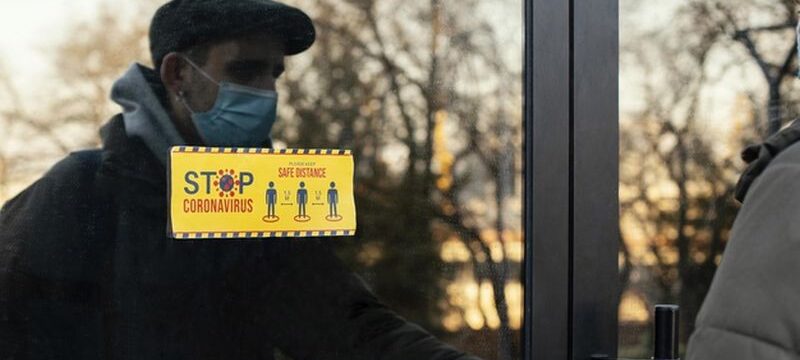 man-with-mask-opening-door_23-2148863843