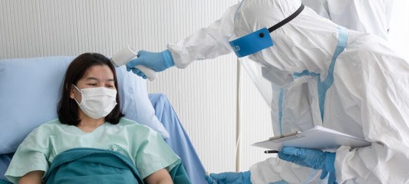 two-doctor-wear-ppe-suit-with-face-mask-measure-body-temperature-coronavirus-infected-patient-with-infrared-thermometer-gun-negative-pressure-quarantine-room_60388-708