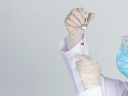 Young doctor is  holding  hypodermic syringe with  vaccine vial