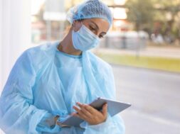 female-doctor-protective-wear-looking-clipboard_23-2148722308