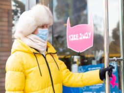 happy-young-woman-door-restaurant-cold-winter-day-lettering-takeaway-food_343596-4738