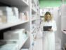 pharmacist-white-uniform-walking-by-shelf-with-medicines-checking-inventory_342744-323