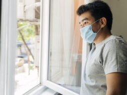 side-view-man-with-medical-mask-home-during-pandemic-looking-through-window_23-2148781390
