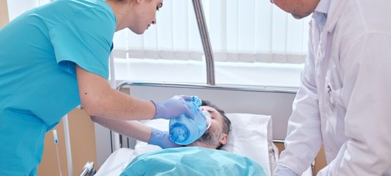 young-nurse-putting-bag-valve-oxygen-mask-patients-face-doctor-checking-his-pulse-while-they-providing-urgent-assistance-man_274679-10057