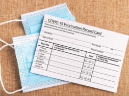 coronavirus-vaccination-record-card-surgical-mask-divided-into-two-parts-syringe-concept-defeating-covid19_332033-1065
