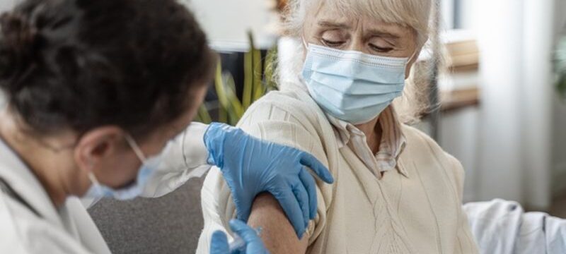doctor-vaccinating-senior-woman_23-2148962364