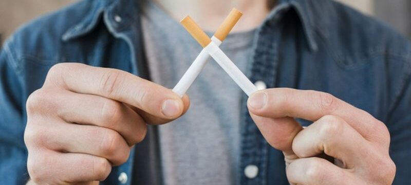 man-s-hand-holding-crossed-cigarettes_23-2148185341