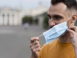 man-taking-off-his-medical-mask-outdoors_23-2148648198