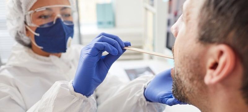 mature-man-opening-mouth-while-doctor-protective-clothing-examining-his-throat-during-medical-exam-hospital_249974-2969