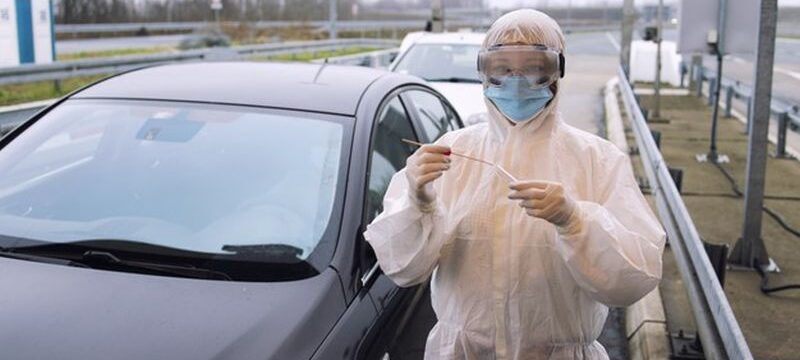 medical-heath-care-worker-protective-white-suit-standing-border-crossing-ready-test-passengers-corona-virus_308072-42