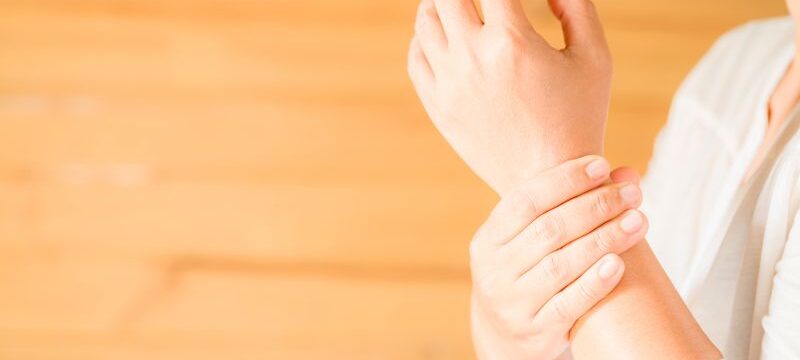 woman holding her wrist symptomatic Office Syndrome