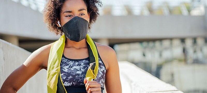 afro-athletic-woman-wearing-face-mask-relaxing-after-work-out-outdoors-street_58466-14593