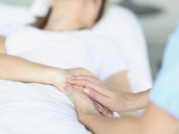 bed-lies-sick-doctor-sitting-him-sympathetically-holds-hand-euthanasia_151013-18147