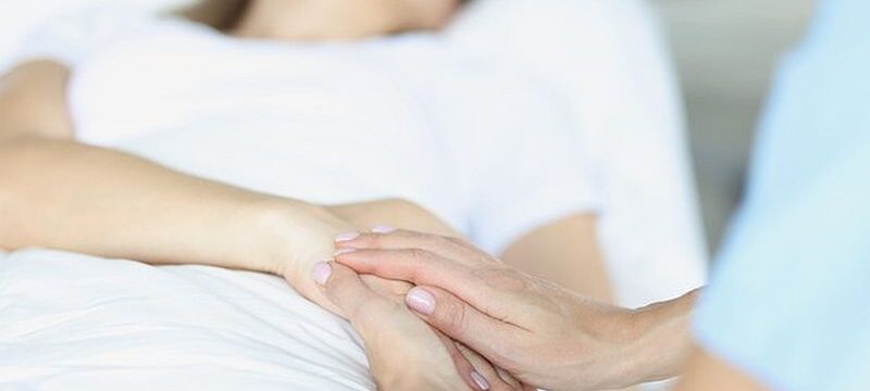 bed-lies-sick-doctor-sitting-him-sympathetically-holds-hand-euthanasia_151013-18147