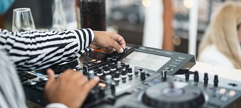 black-dj-playing-music-cocktail-bar-outdoor-while-wearing-face-safety-mask-entertainment-social-distance-party-concept-focus-left-hand_166273-1414