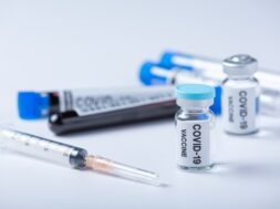 close-up-vial-covid-19-vaccine-hand-scientist-doctor_1150-44139