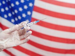 doctor-s-hand-holding-syringe-with-vaccine-united-states-america-flag_167187-1299