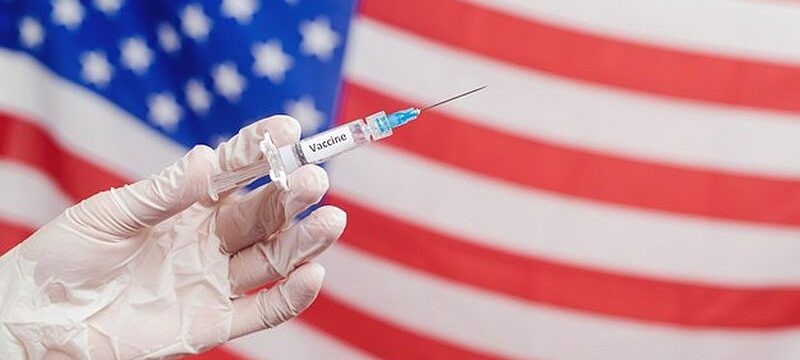 doctor-s-hand-holding-syringe-with-vaccine-united-states-america-flag_167187-1299