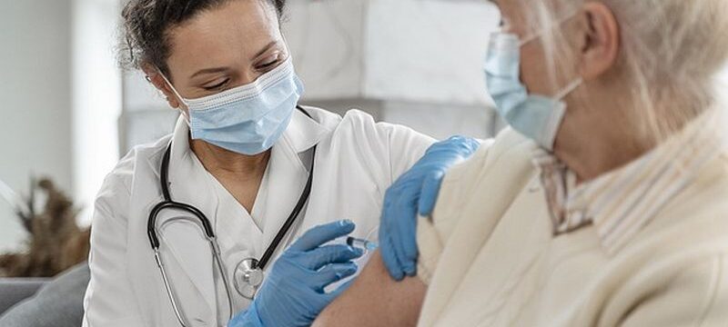 doctor-vaccinating-senior-woman_23-2148962365