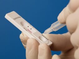 macro-shot-hands-conducting-coronavirus-test-blue-background_362520-454