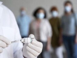 male-medic-holding-vaccine-vial-with-syringe_23-2148988253