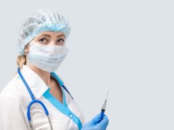 masked-nurse-with-phonendoscope-holds-syringe-with-medicine_326821-256