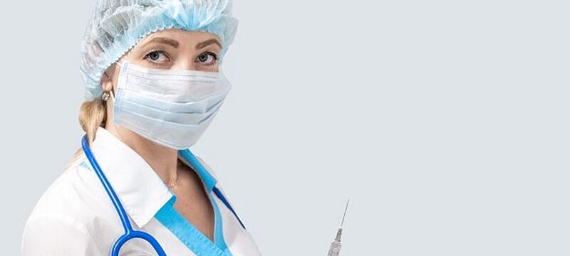 masked-nurse-with-phonendoscope-holds-syringe-with-medicine_326821-256