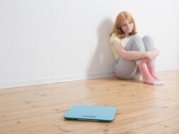 sad-teenager-girl-with-scale-wooden-floor_176873-5477