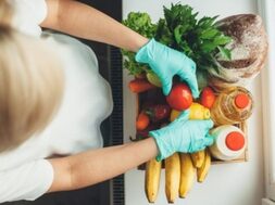 upper-view-photo-caucasian-woman-unpacking-products-during-lockdown-wearing-gloves_129180-1973