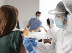 vaccination-center-with-doctor-holding-syringe_23-2148976696