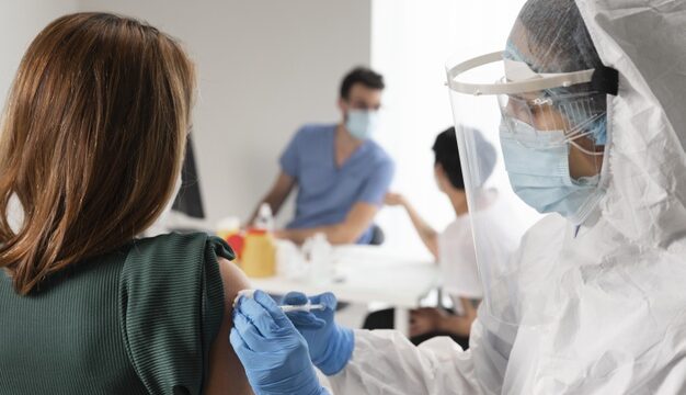 vaccination-center-with-doctor-holding-syringe_23-2148976696