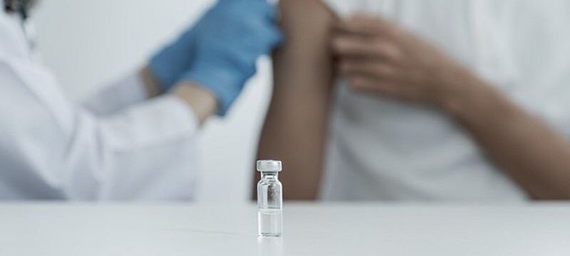 vaccine-table-doctor-holding-syringe-was-about-vaccinate-patient-clinic-prevent-spread-virus_177530-447