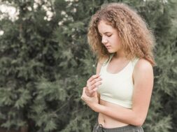 young-female-athlete-having-wrist-pain-standing-against-tree_23-2147889000